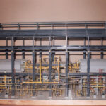 Detailed industrial scale model featuring precision piping, machinery and fabricated components